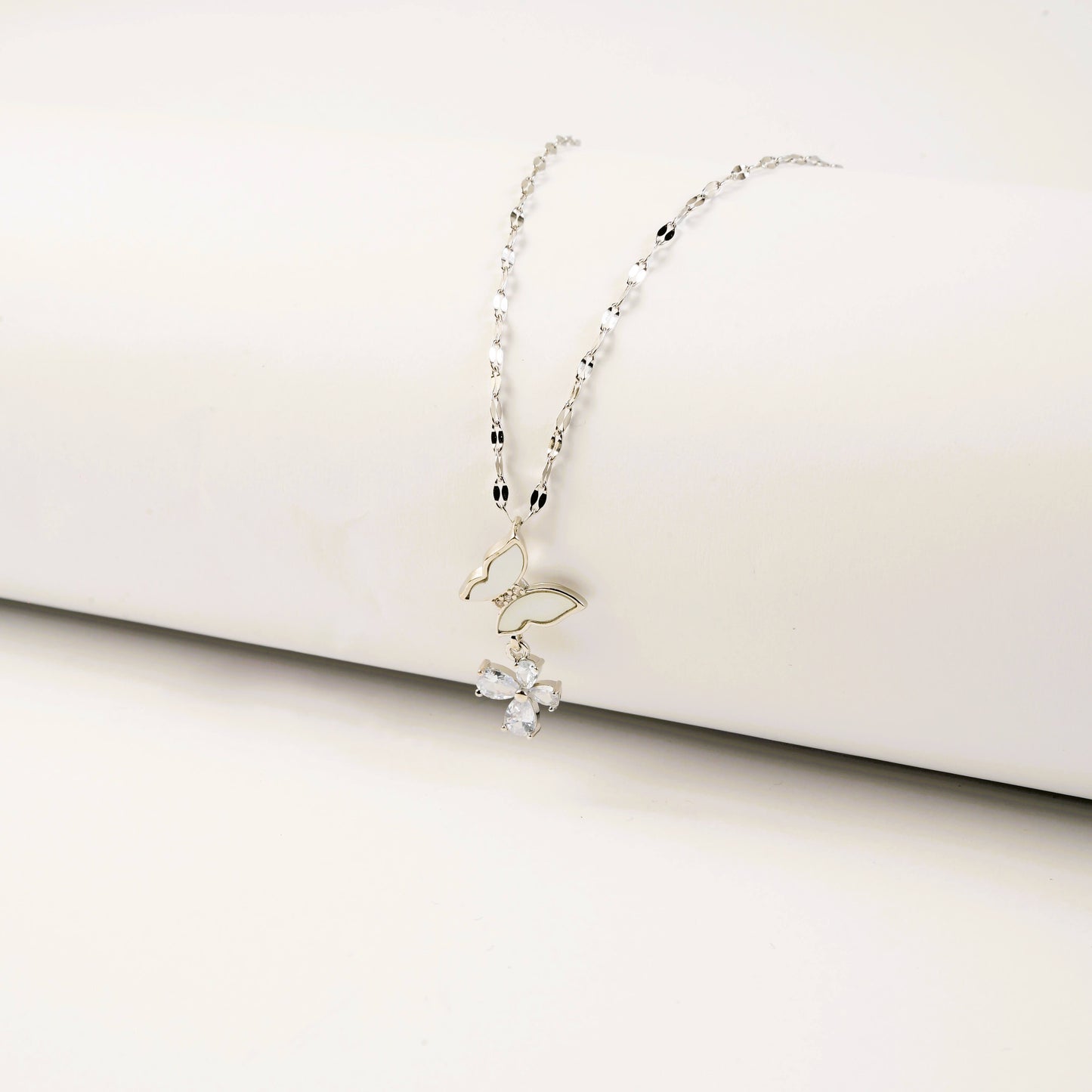 Delicate silver necklace on a white surface