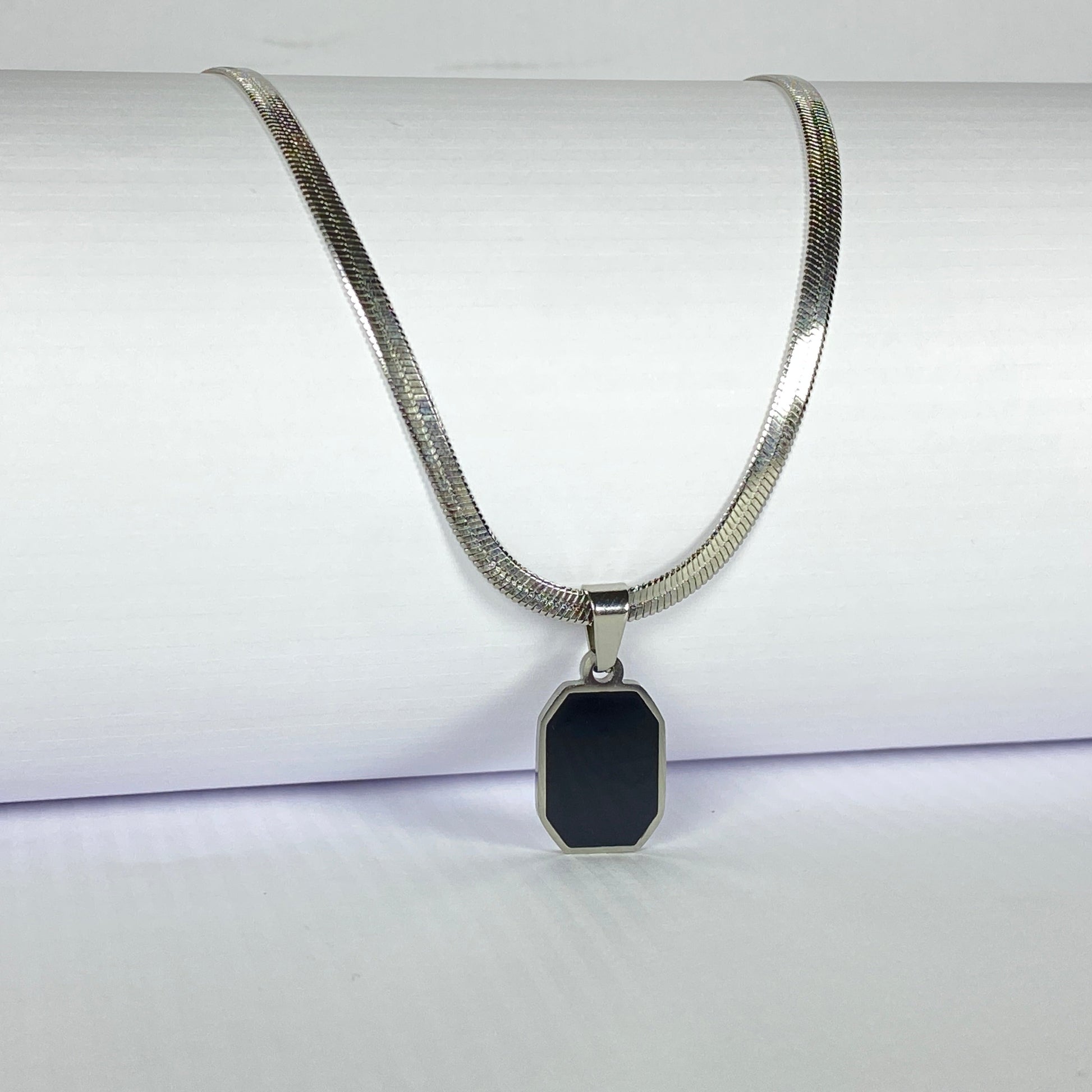Necklace with a black pendant on a white background
