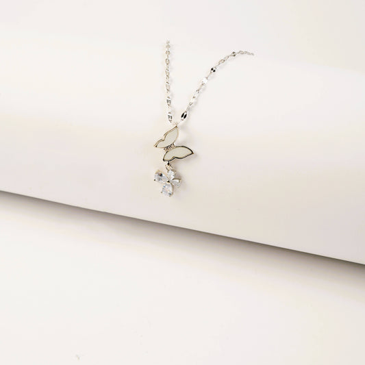 Delicate silver necklace with a small pendant on a light beige background
