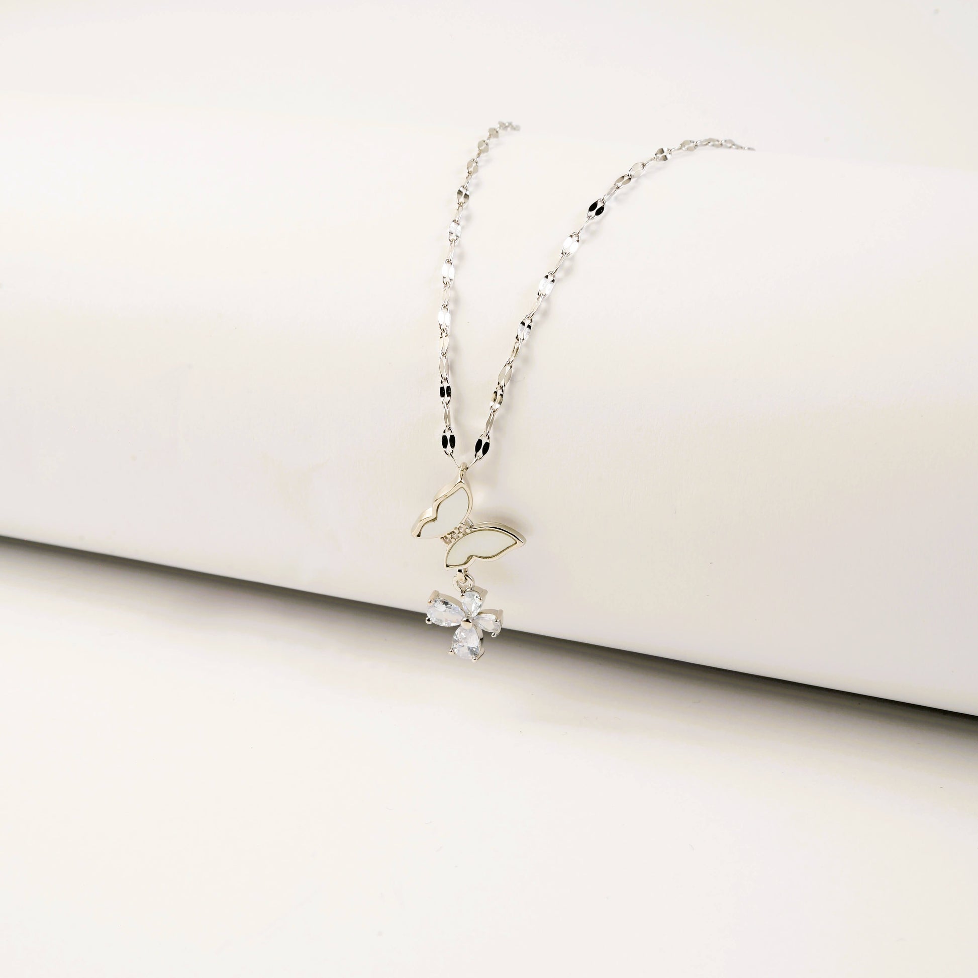 Delicate silver necklace on a white surface